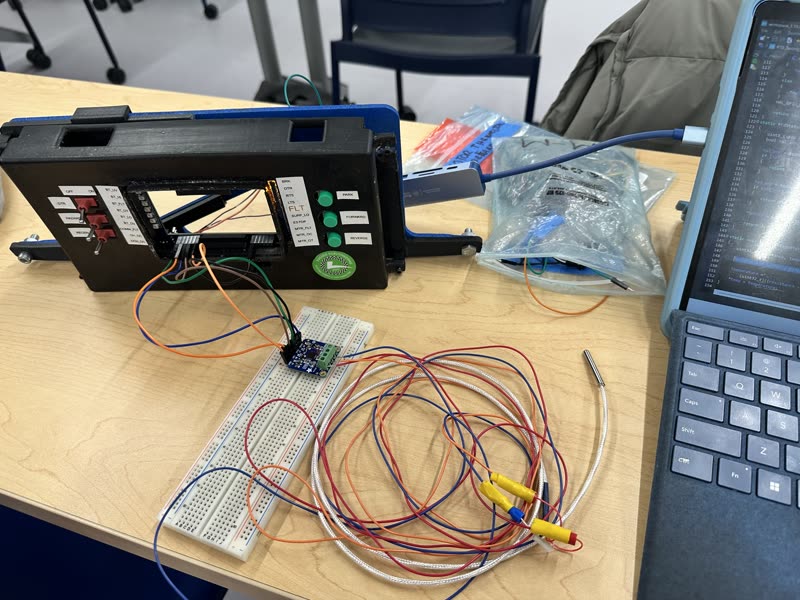 A MAX31865 breakout on a breadboard wired to an RTD probe, next to a laptop