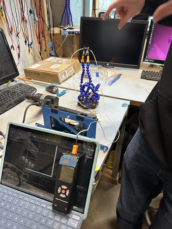 The heat-gun test bench: a heat gun on the probe, a thermocouple meter and a laptop